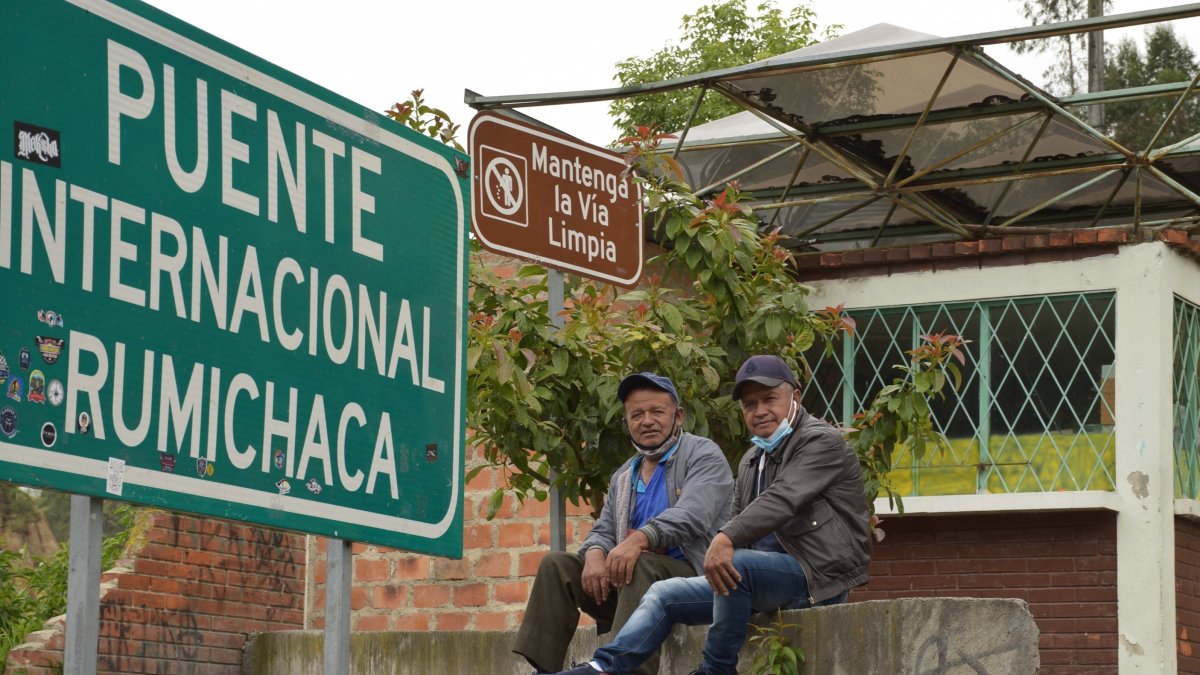Dos conductores ecuatorianos esperan en el paso de Rumichaca a la devolución de su camión desde Colombia por un conductor de ese país antes de la reapertura de la frontera.