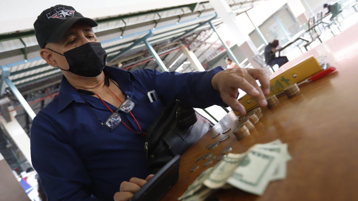 Una foto referencial de como los trabajadores están contando su dinero para ver para qué le alcanza al haber recibido un décimo recortado.