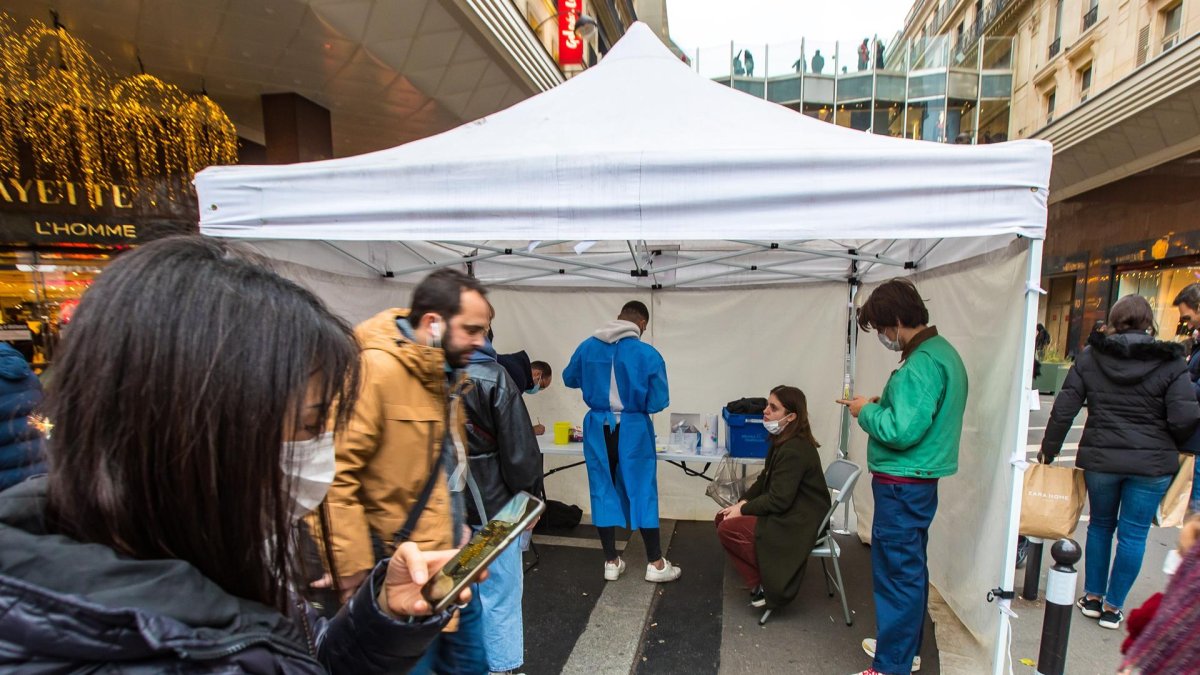 Varias personas esperan para someterse a una PCR en un centro móvil en París.