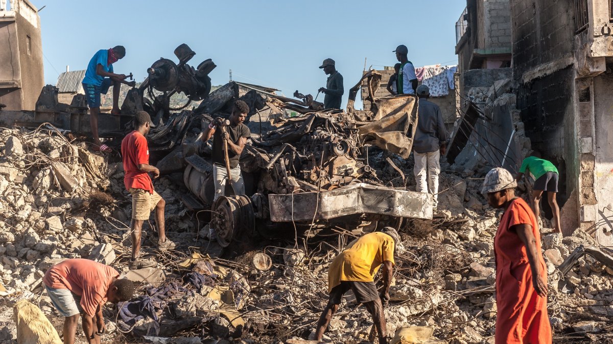Un grupo de personas buscan hierro en una casa demolida, el 16 de diciembre de 2021, en Cap-Haitien (Haití).  Johnson Sabin