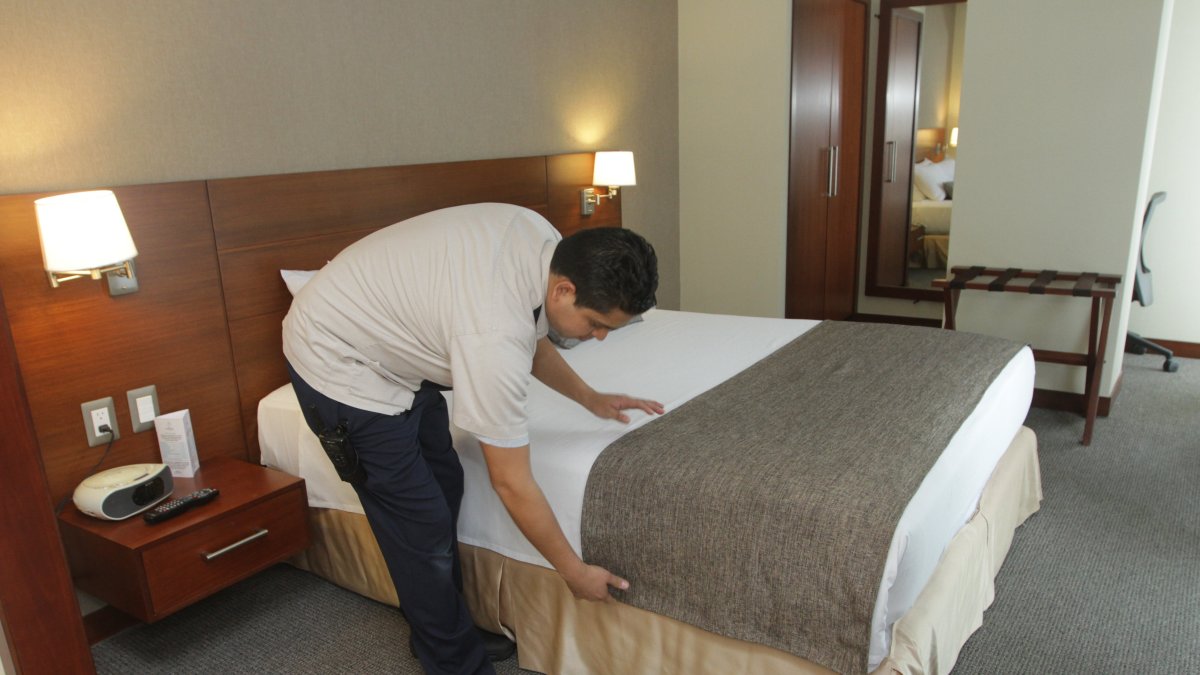 Una persona arregla la cama en un hotel de Guayaquil.