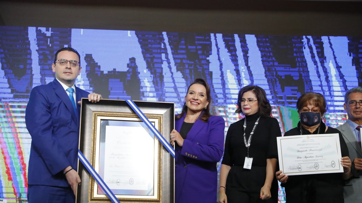 Kelvin Aguirre, presidente consejero del Consejo Nacional Electoral, posa junto a la presidenta electa de Honduras, Xiomara Castro (c), durante la entrega de credenciales en el Hotel Plaza Juan Carlos, hoy, en Tegucigalpa 