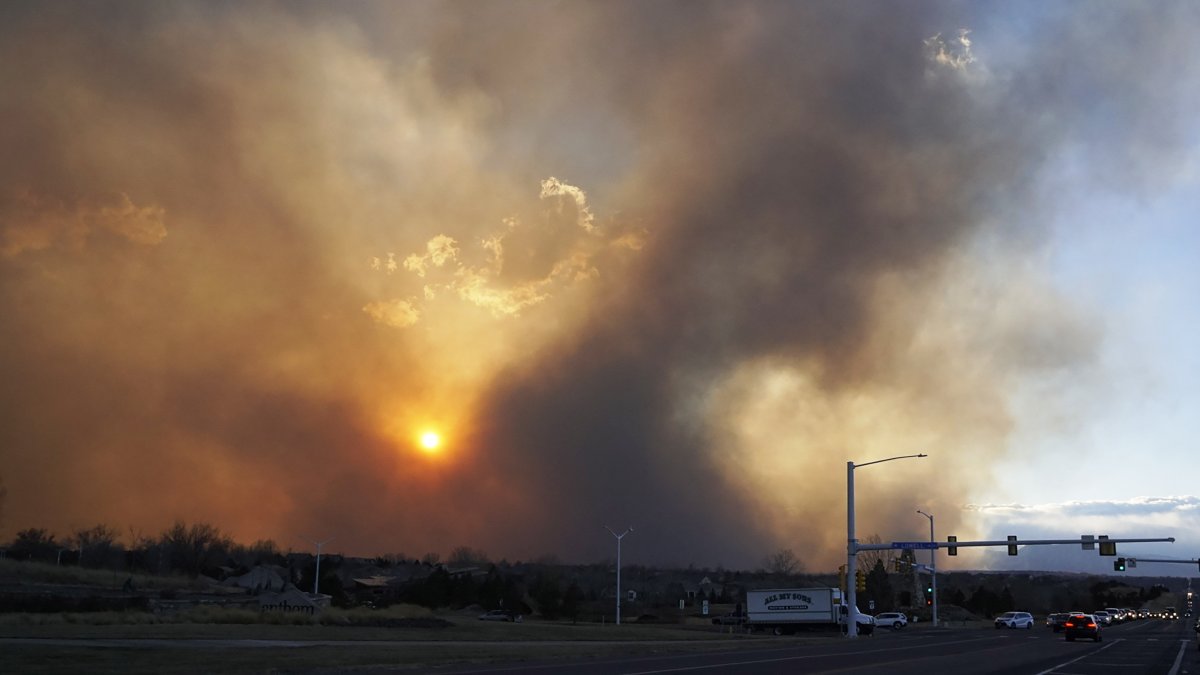 Así se observaba al mediodía de ayer uno de los puntos de ingreso a esta localidad. El fuego seguía ardiendo al fondo. / EFE