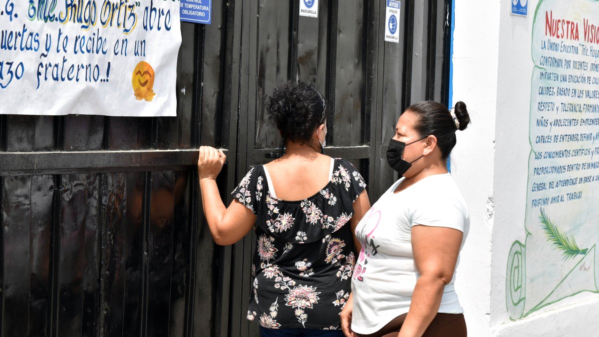 Plantel. Madres analizan qué tipo de seguridad le urge al portón de la Unidad Educativa Teniente Hugo Ortiz.