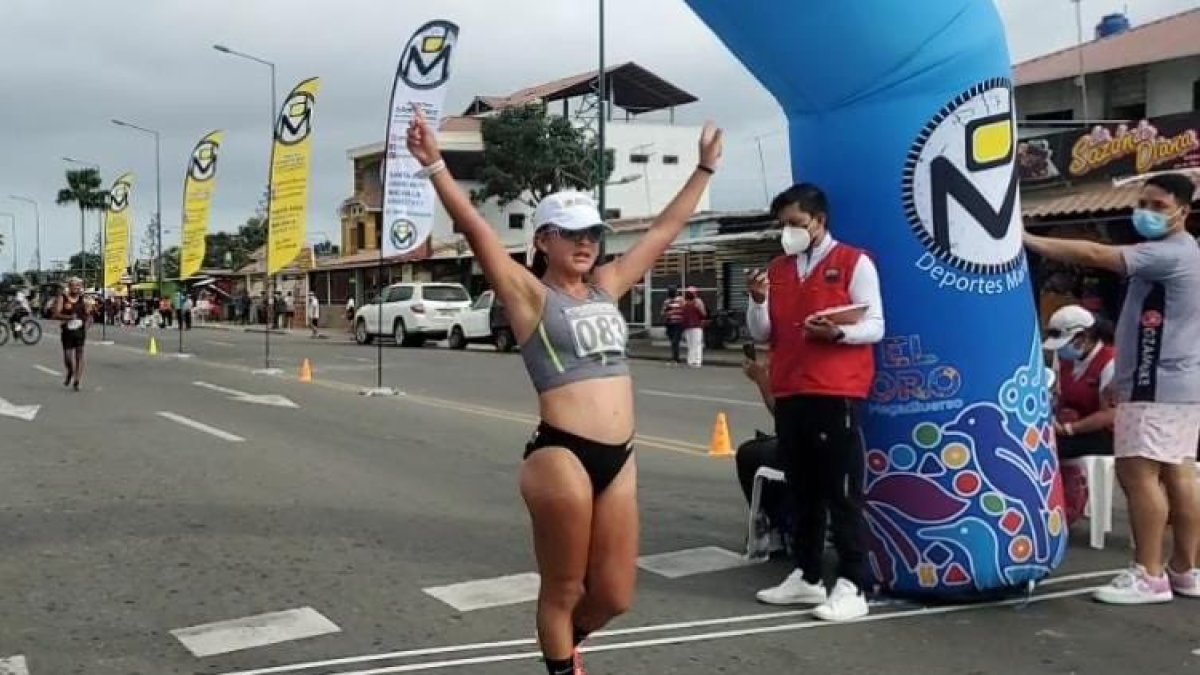La marchista ecuatoriana Glenda Morejón levanta sus brazos tras cruzar la meta.