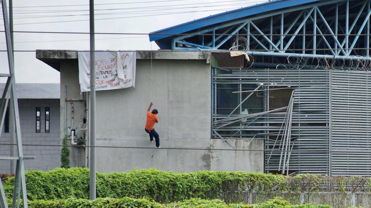 Fotografía de archivo, tomada el pasado 25 de febrero, en la que se registró a un preso al descender por una pared, durante un motín, en una cárcel de Guayaquil
