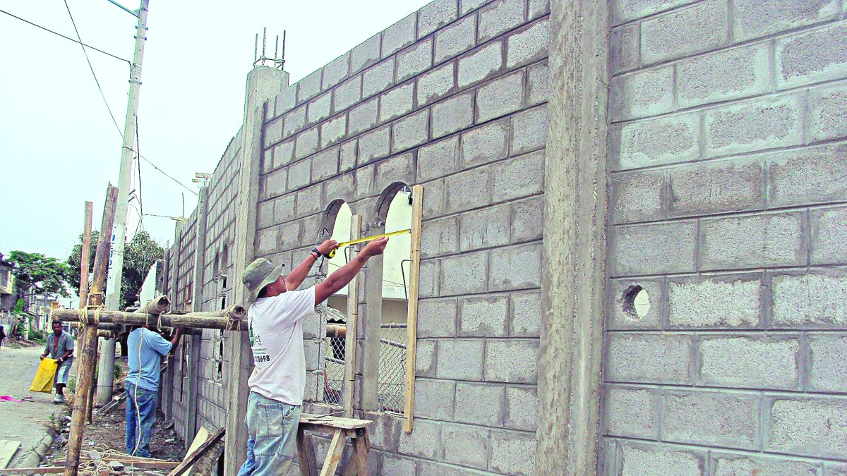 Trabajo.- Albañiles en una construcción de casas.