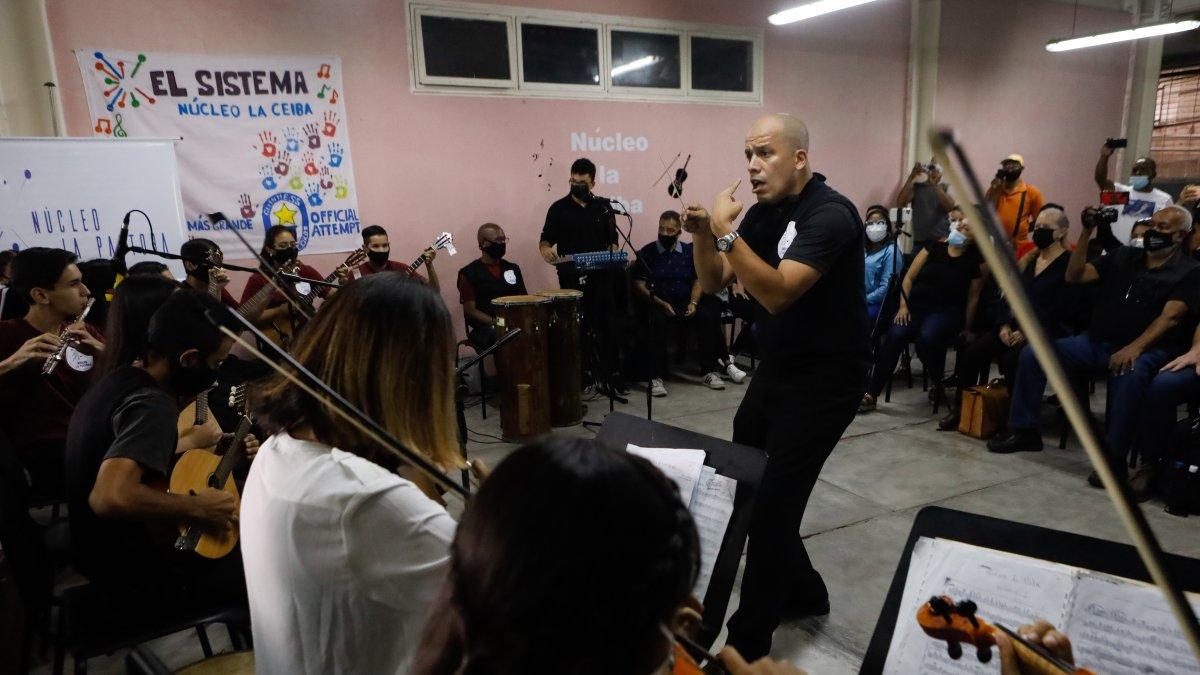 Un maestro de música dirige un concierto de 'El Sistema' para invitados extranjeros.