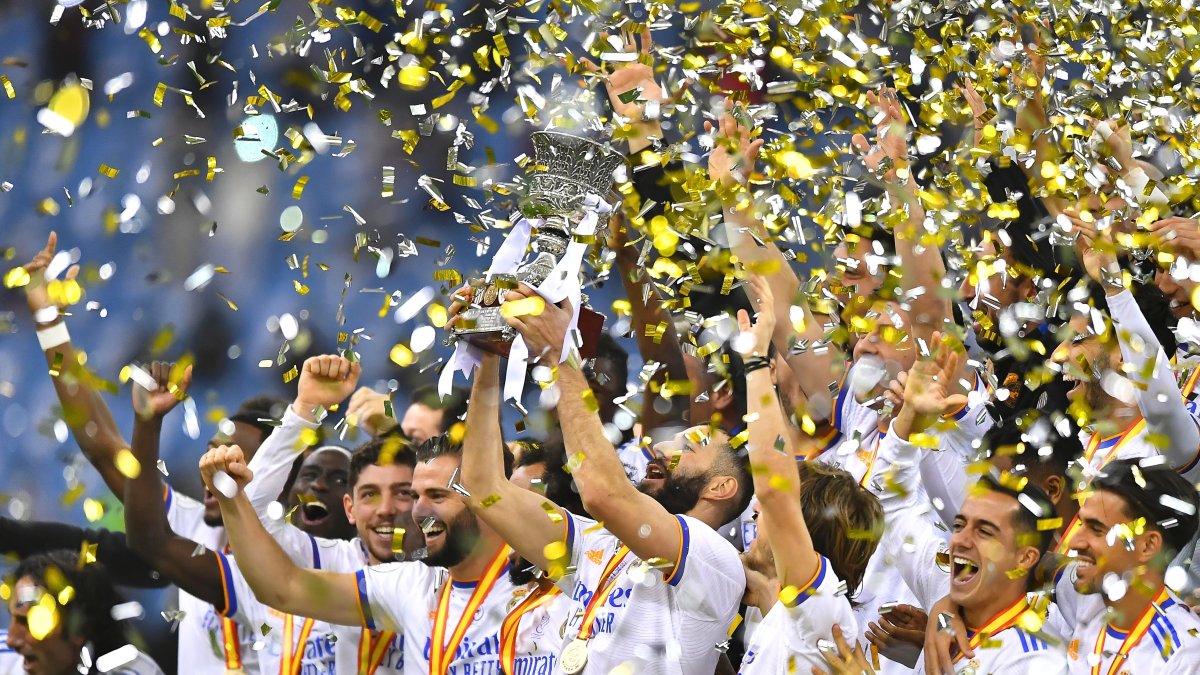 Karim Benzema (c), autor de uno de los dos tantos del equipo, levanta el trofeo de monarcas.