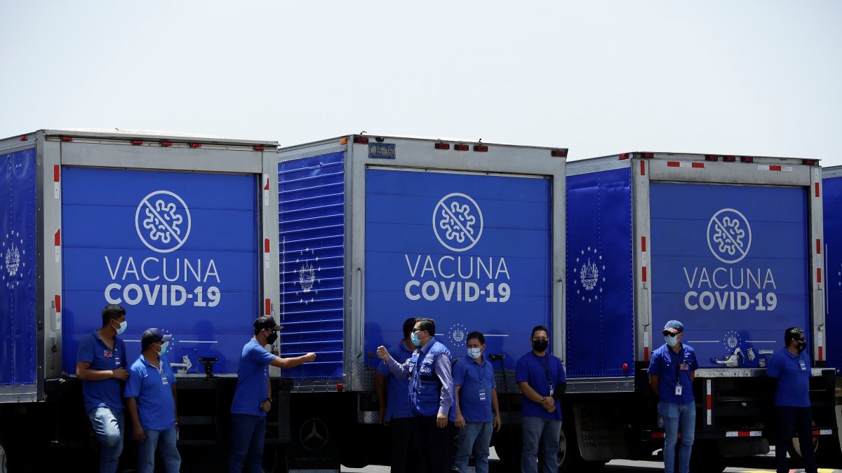 Vista de trabajadores de la salud junto a camiones refrigerantes que transportarán un lote de vacunas, en una fotografía de archivo.