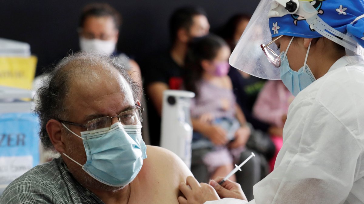 Fotografía de archivo de un hombre mientras recibe una dosis de la vacuna contra la covid-19 en Bogotá (Colombia).