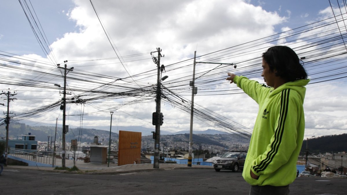 Las Casas. Erick Zumba señala la cantidad de cables que están desordenados en un poste en este sector.