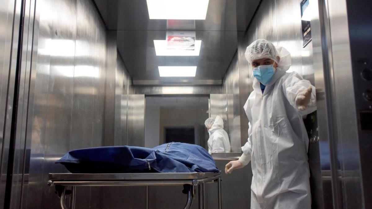 Personal de salud traslada a un paciente fallecido por la covid-19