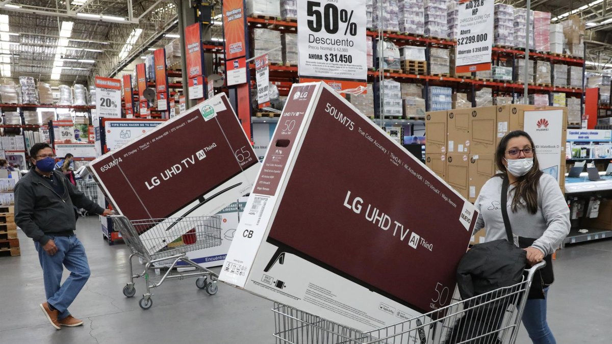 Compradores salen de un almacén llevando electrodomésticos en Bogotá (Colombia), en una fotografía de archivo.
