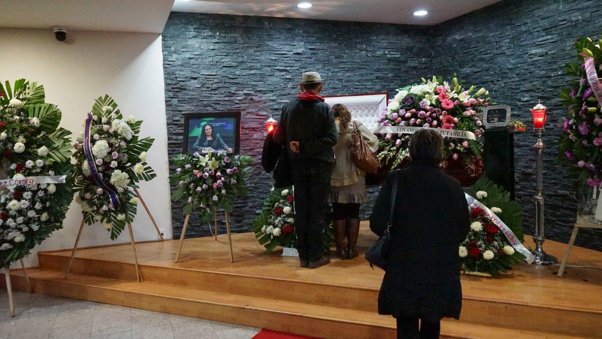 Tres personas se acercan al féretro durante el funeral de la periodista Lourdes Maldonado .  Joebeth Terriquez