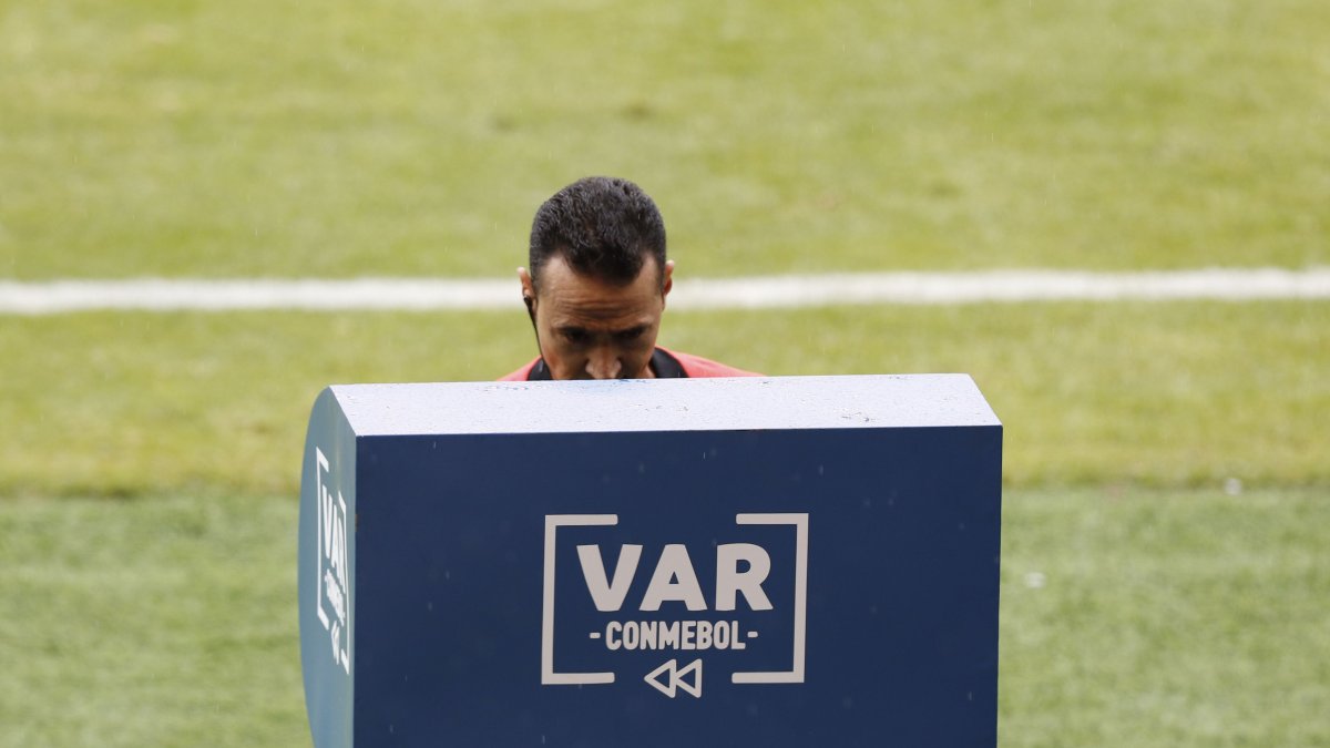 Wilmar Roldán observa el VAR para cambiar la expulsión del arquero brasileño Alisson por una amonestación.