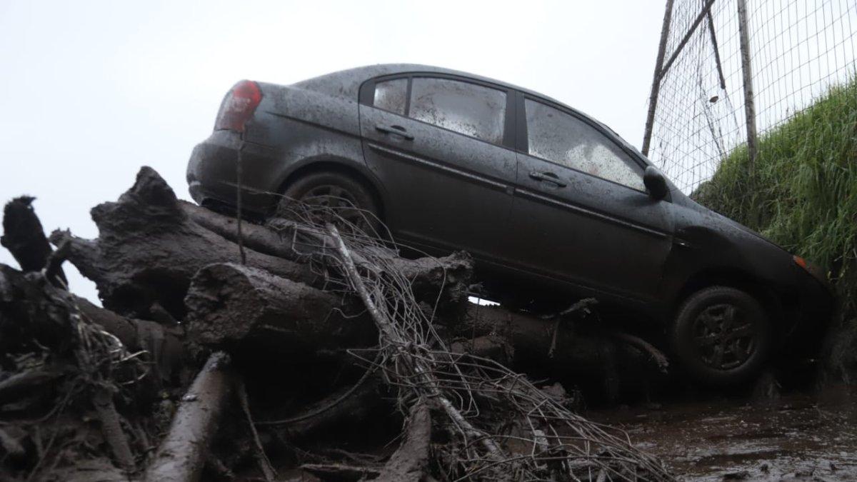 Daños. Decenas de vehículos arrastrados por la corriente terminaron en montículos de troncos y árboles en el sector de La Comuna.