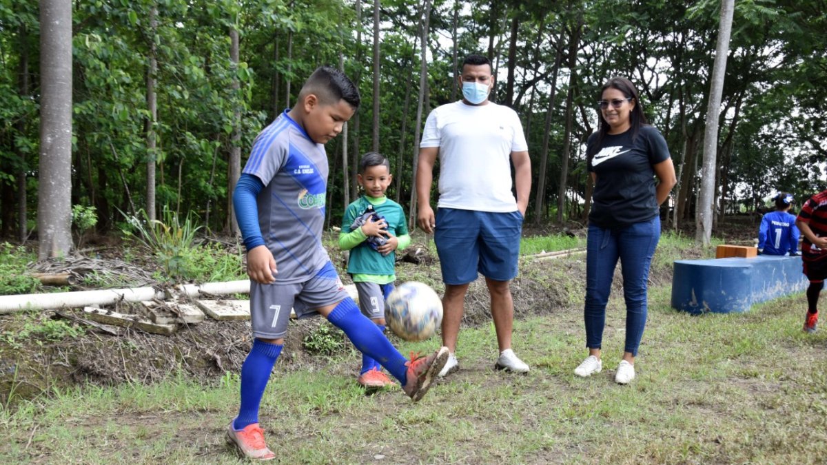 Johnny mientras domina el esférico en uno de los calentamientos. Lo miran orgulloso su padre, Johnny Morales, y su mamá, Leonela.