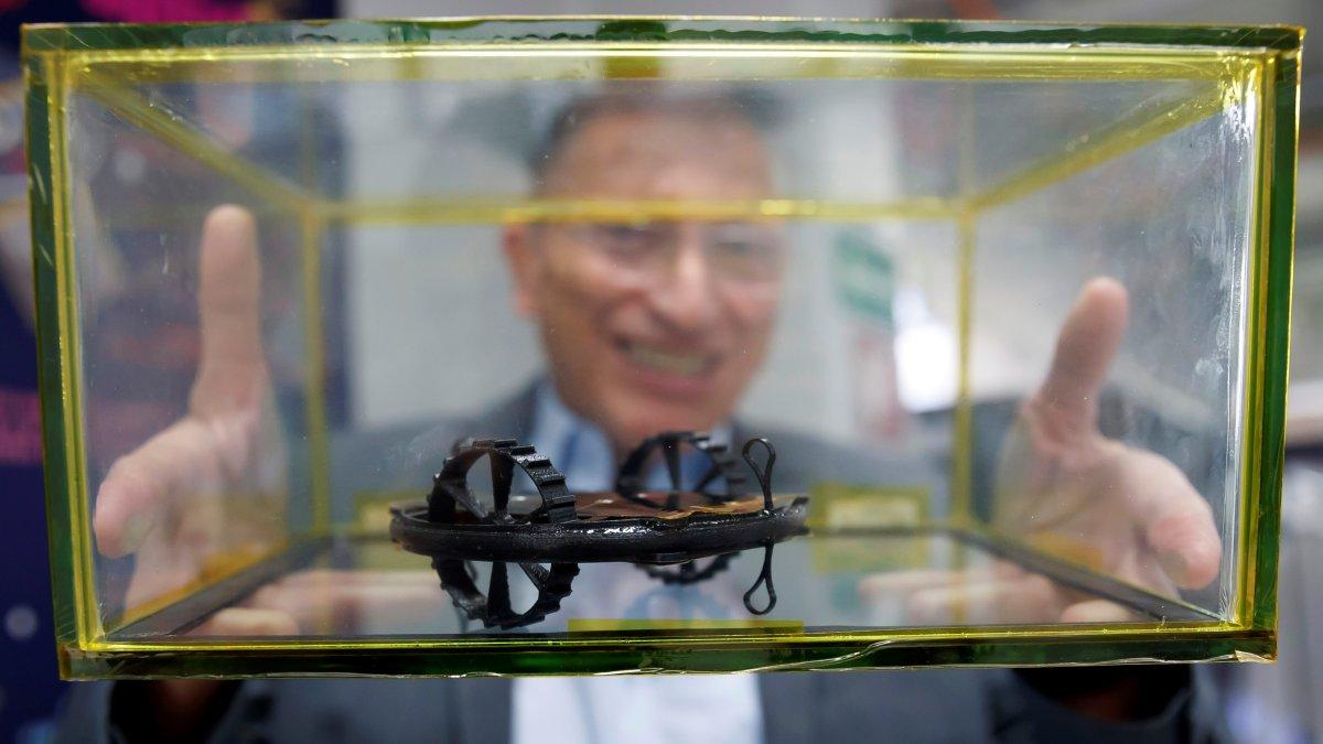 El doctor Gustavo Medina Tanco muestra una catapulta, uno de los diminutos robots que aterrizarán en la luna a mediados de año para estudiar su superficie.  