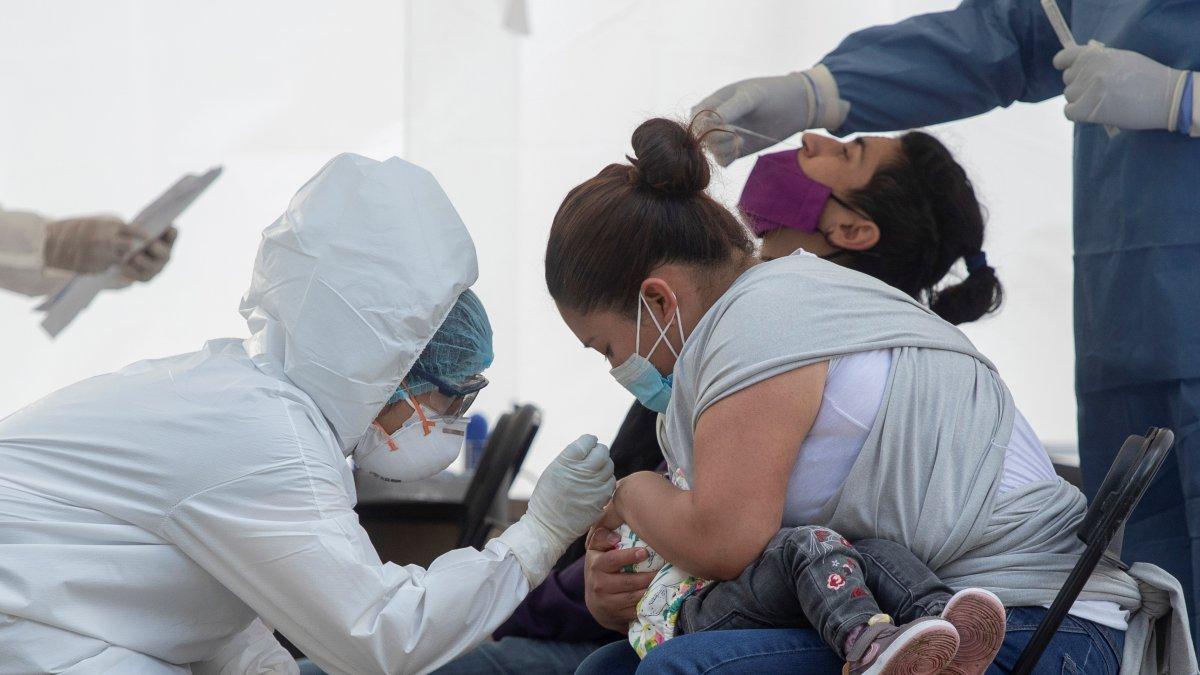 Una madre sostiene a su hija durante una prueba para detectar la covid-19 en el Hospital del IMSS 