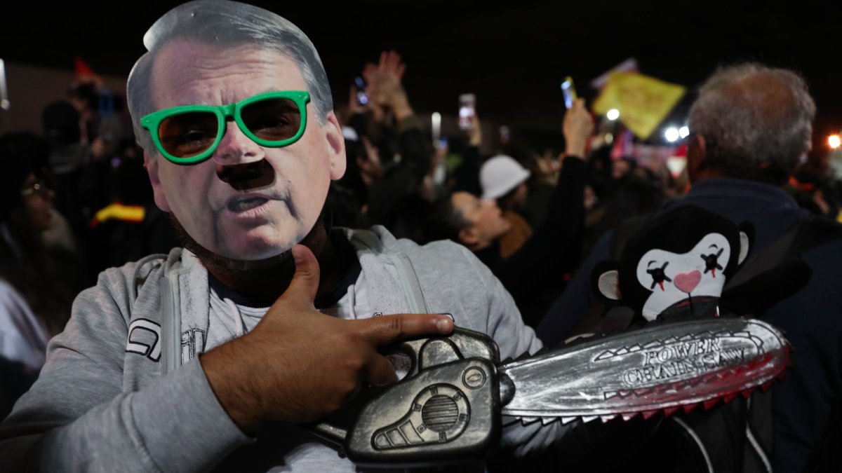 Fotografía de archivo del 23 de agosto de 2019 que muestra a un manifestante con una máscara alusiva al presidente de Brasil, Jair Bolsonaro, durante una protesta por su política frente a la Amazonía, en Sao Paulo (Brasil).
