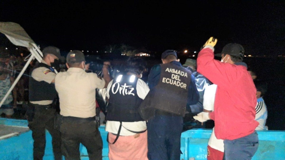 Policías y pescadores desembarcan el cuerpo que fue hallado en altamar, entre las redes de un pescador.