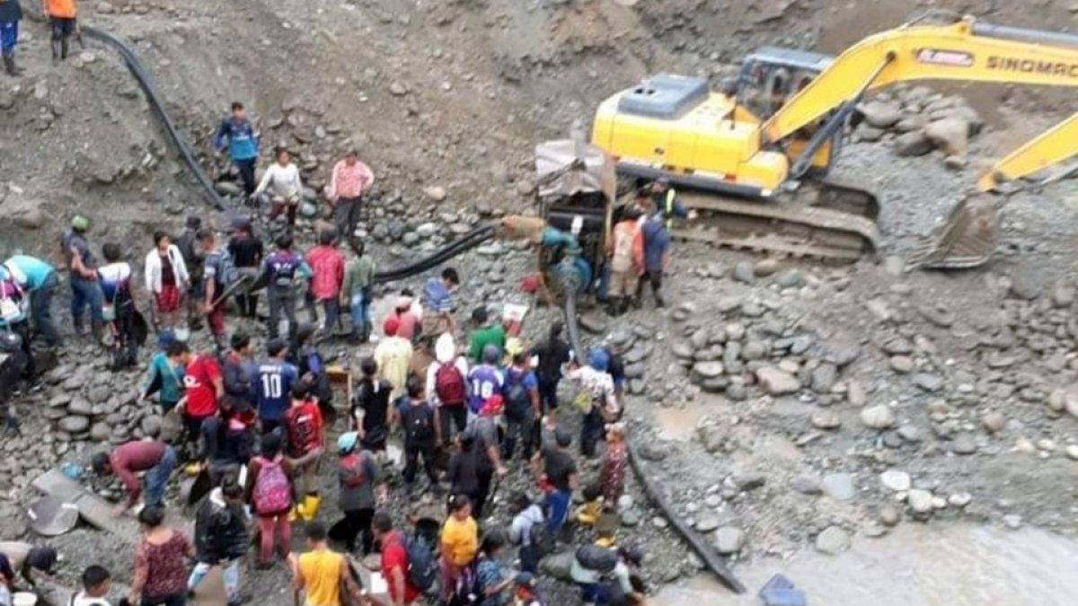 Cientos de personas y maquinaria pesada extraen oro durante el día.