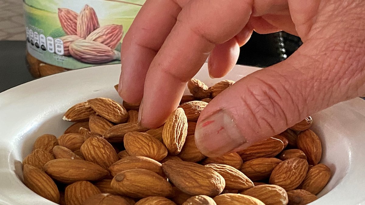 Una persona come almendras como parte de su dieta alimenticia