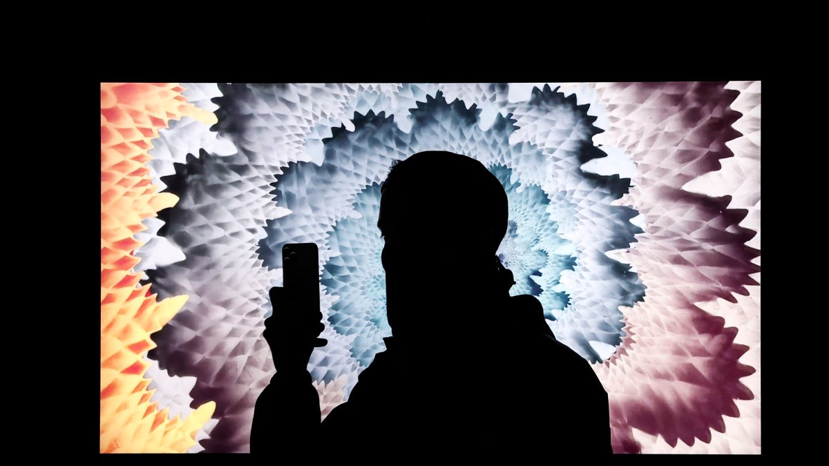 Imagen de archivo de una persona que toma una foto de una obra de arte digital de NFT