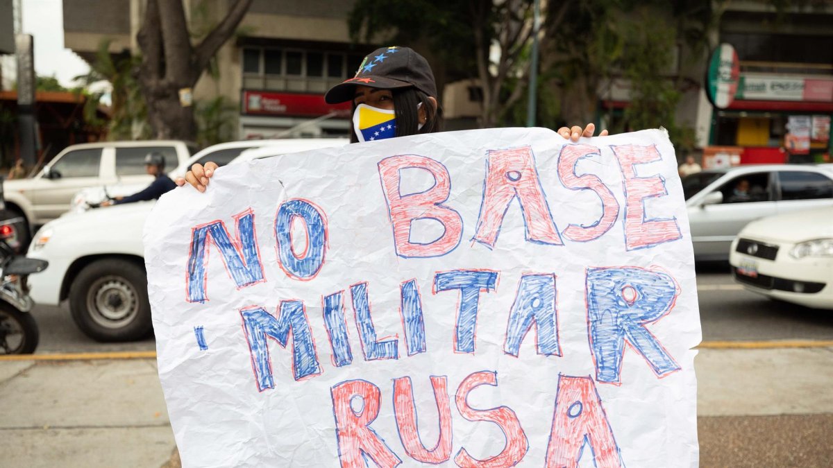 Una mujer fue registrada este viernes con una pancarta que dice