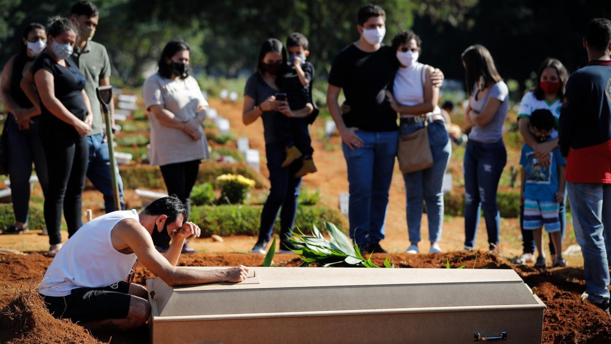 Fotografía de archivo en al que se registró a una familia durante el entierro de un familiar víctima de la covid-19, en el cementerio Vila Formosa, en Sao Paulo (Brasil).