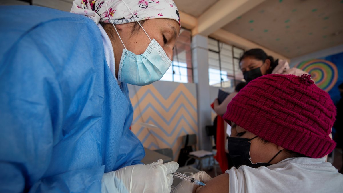 Fotografía de archivo en la que se registró a un niño al ser vacunado contra la covid-19, en un colegio de Quito
