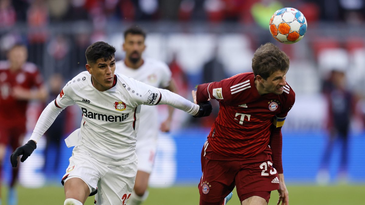 El ecuatoriano Piero Hincapié (izquierda) disputa el balón con el delantero del Bayer de Múnich, Thomas Müller.