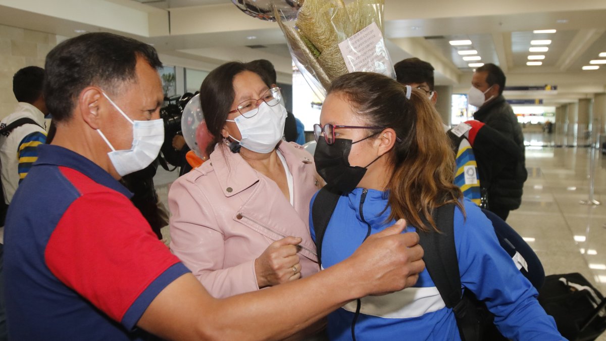 La campeona mundial de marcha, Glenda Morejón, fue recibida en el aeropuerto por sus padres, quienes le llenaron de abrazos y le entregaron flores y un globo.