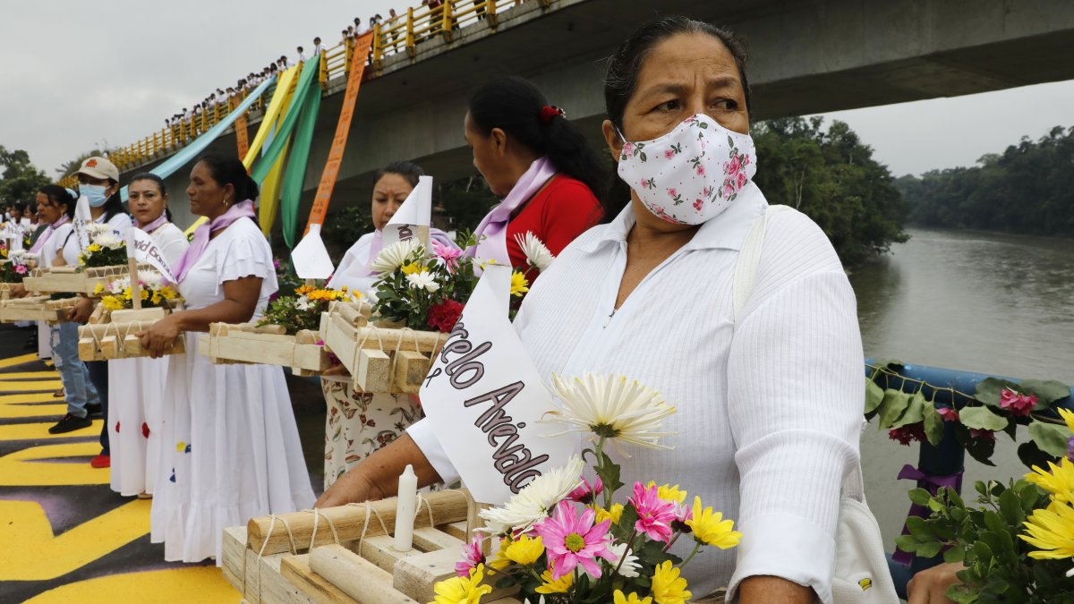 Un grupo de mujeres que sostiene balsas con flores y nombres de víctimas de la violencia en El Tigre, departamento del Putumayo (Colombia).  Carlos Ortega