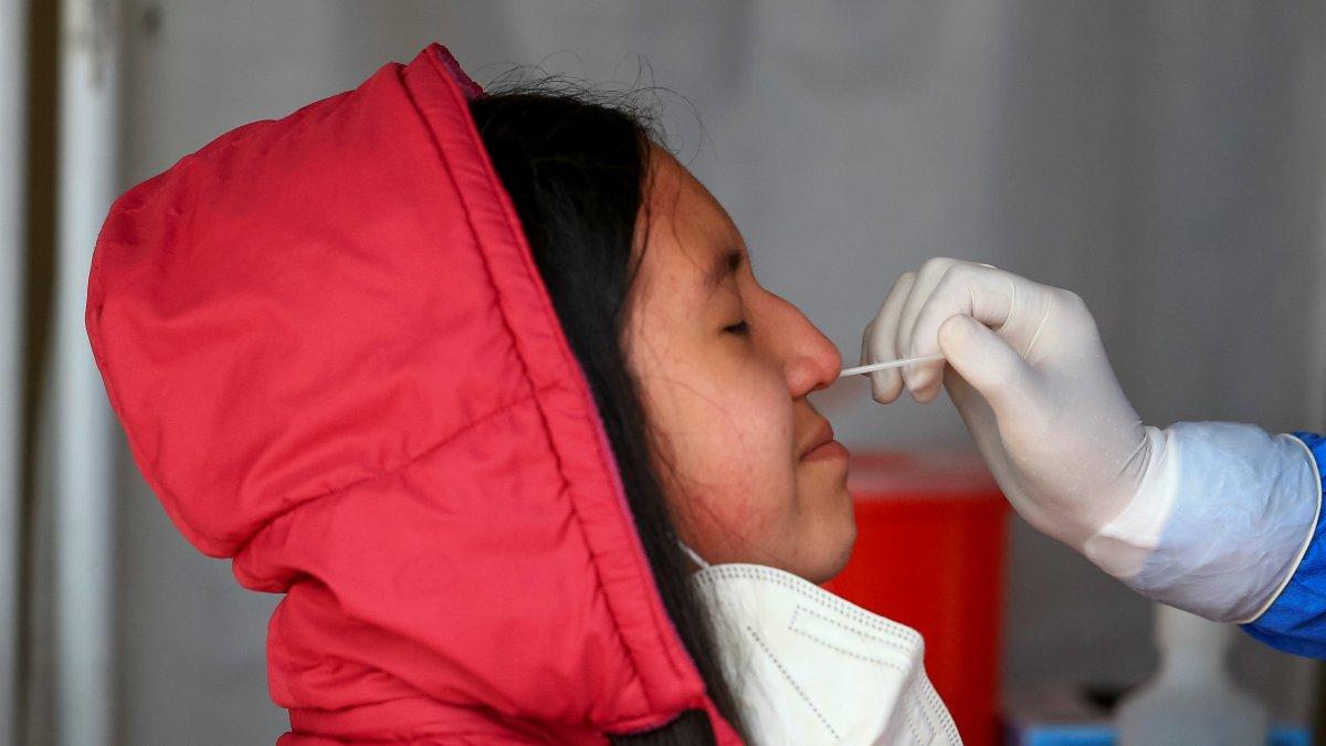 Fotografía de archivo de una mujer mientras se realiza una prueba PCR para detectar covid-19 en Quito (Ecuador).