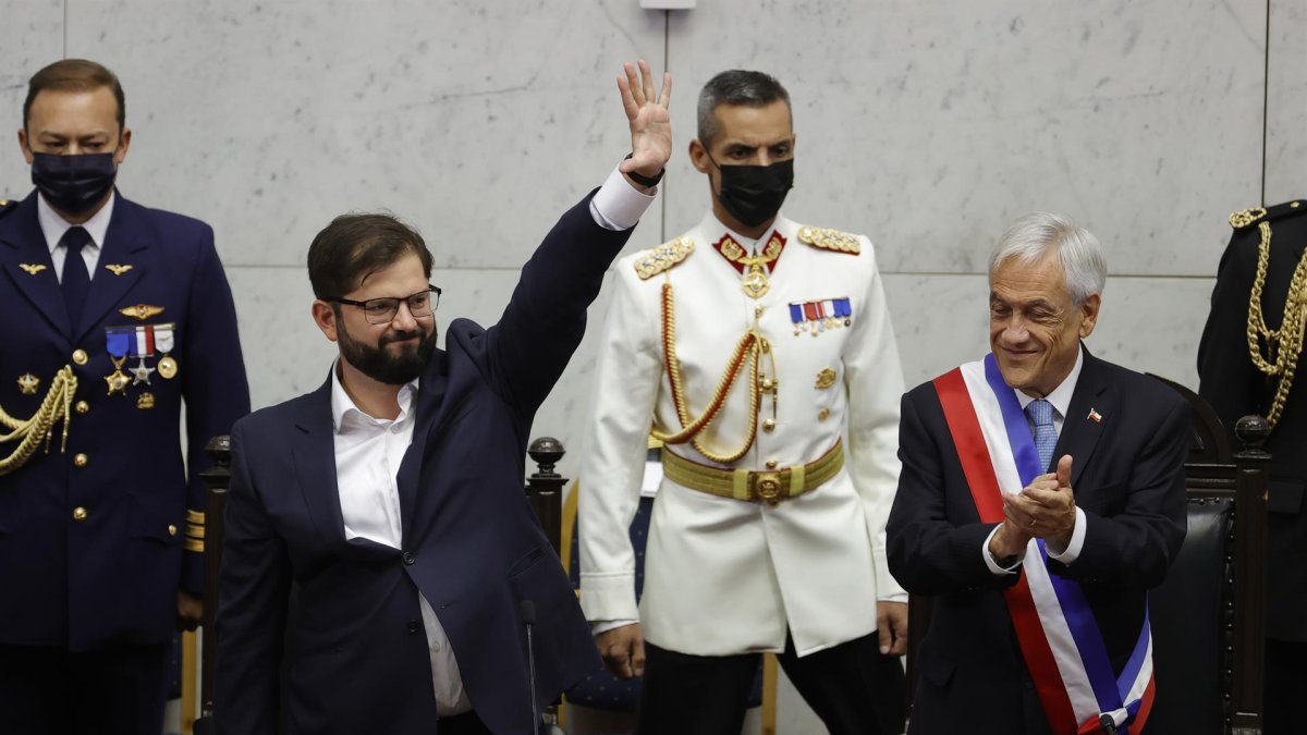 El presidente electo de Chile Gabriel Boric saluda a los asistentes al Congreso Nacional antes de recibir la banda presidencial del saliente mandatario Sebastián Piñera (d) hoy en Valparaiso (Chile).
