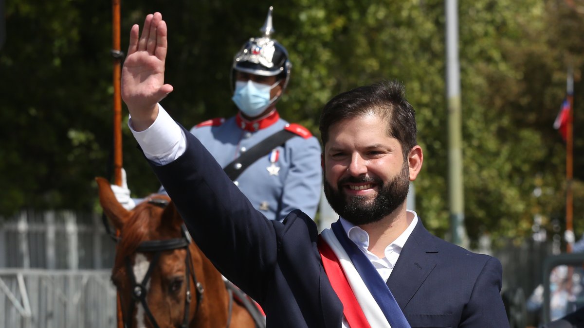 El presidente de Chile, Gabriel Boric, saluda a bordo del vehículo presidencial Ford Galaxie donado por la reina Isabel II de Ingalterra.