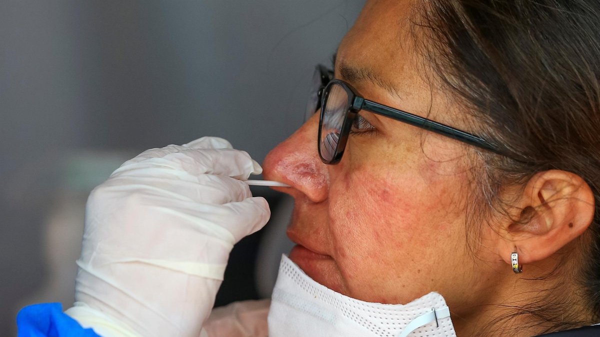 Fotografía de archivo de una mujer mientras se realiza una prueba PCR para detectar covid-19 en Quito (Ecuador).