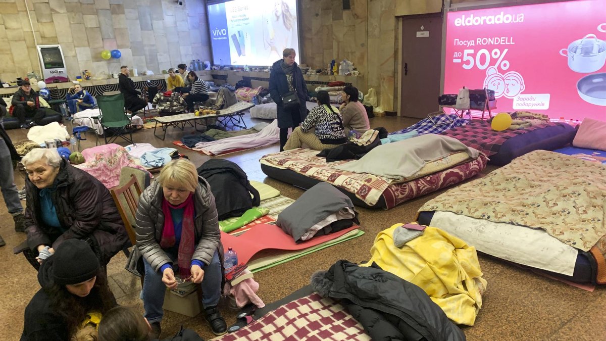 Varias personas permanecen en el interior de la estación de metro 'Héroes de Dnipra', este lunes en Kiev (Ucrania). 