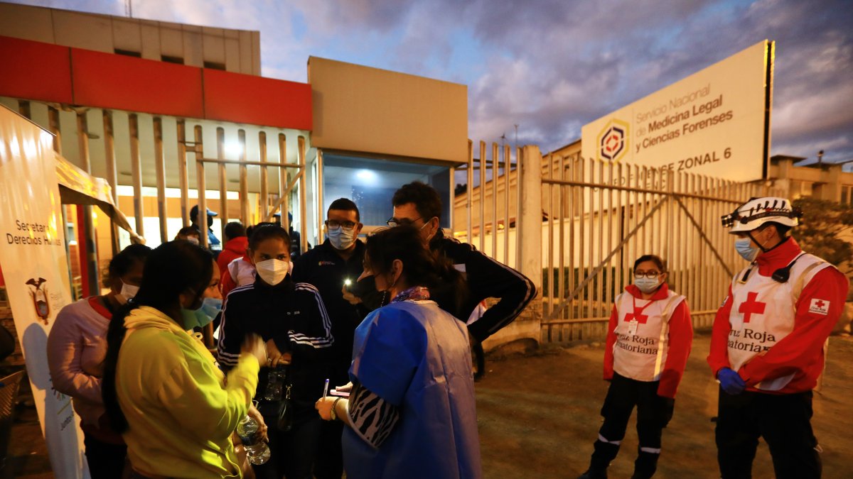 Familiares de reos asesinados, esperan información en los exteriores del centro forense en la ciudad de Cuenca (Ecuador), este 3 de marzo de 2022.