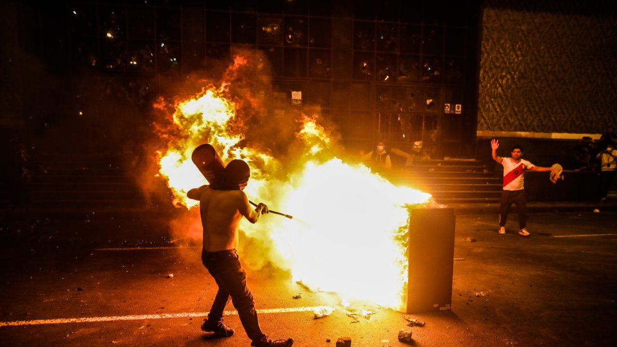 Un manifestante fue registrado este martes al tratar de apagar un incendio, durante una manifestación, a las afueras de la sede de la Corte Suprema, en Lima (Perú).