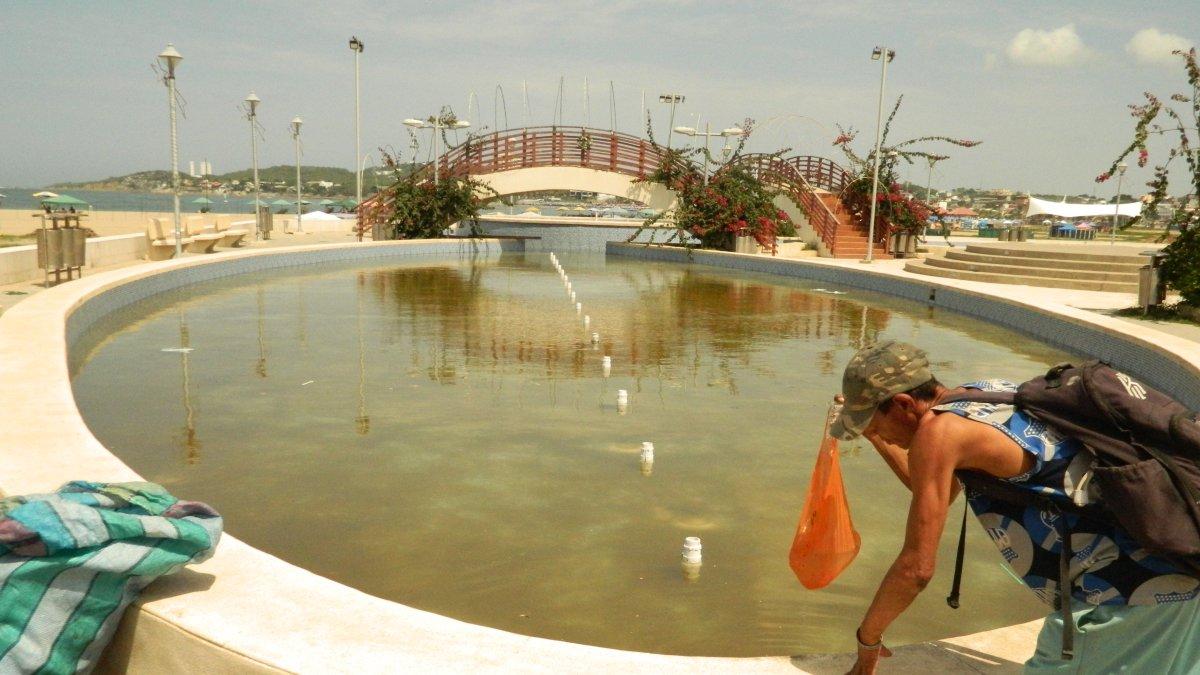 Abandono. Un hombre se acerca a retirar de las piletas, que permanecen apagadas y con el agua estancada, una funda que flotaba en la estructura.