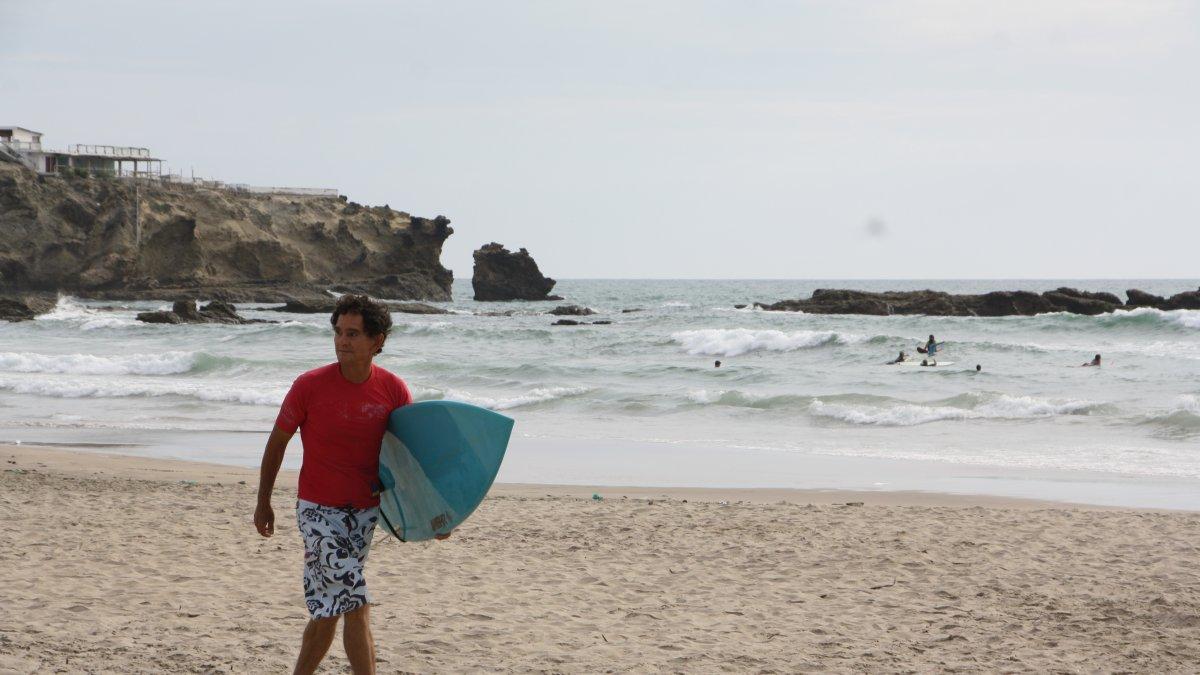 Ritual. Marco Campos, deportista e impulsor del surf en el Ecuador, recorre con su tabla la playa todas las tardes en busca de buenas olas.