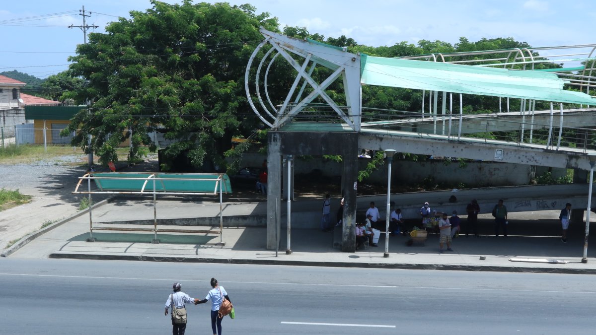 Peatón. Dos mujeres cruzan casi corriendo la vía, ante el deterioro del paso peatonal del sector donde ocurrió un accidente.