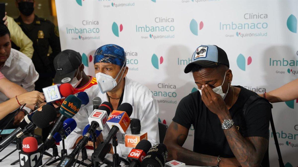 Fotografía cedida hoy por la Alcaldía de Cali que muestra al médico Laureano Quintero (c), director médico de la clínica Imbanaco de Cali, mientras anuncia a los medios de comunicación la muerte del exfutbolista colombiano Fredy Rincón en compañía de sus hijos