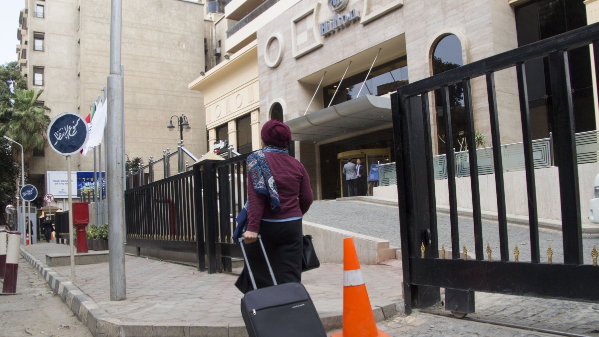  Una mujer egipcia con su maleta pasa ante un hotel en el barrio de Zamalek en El Cairo (Egipto). EFE/  