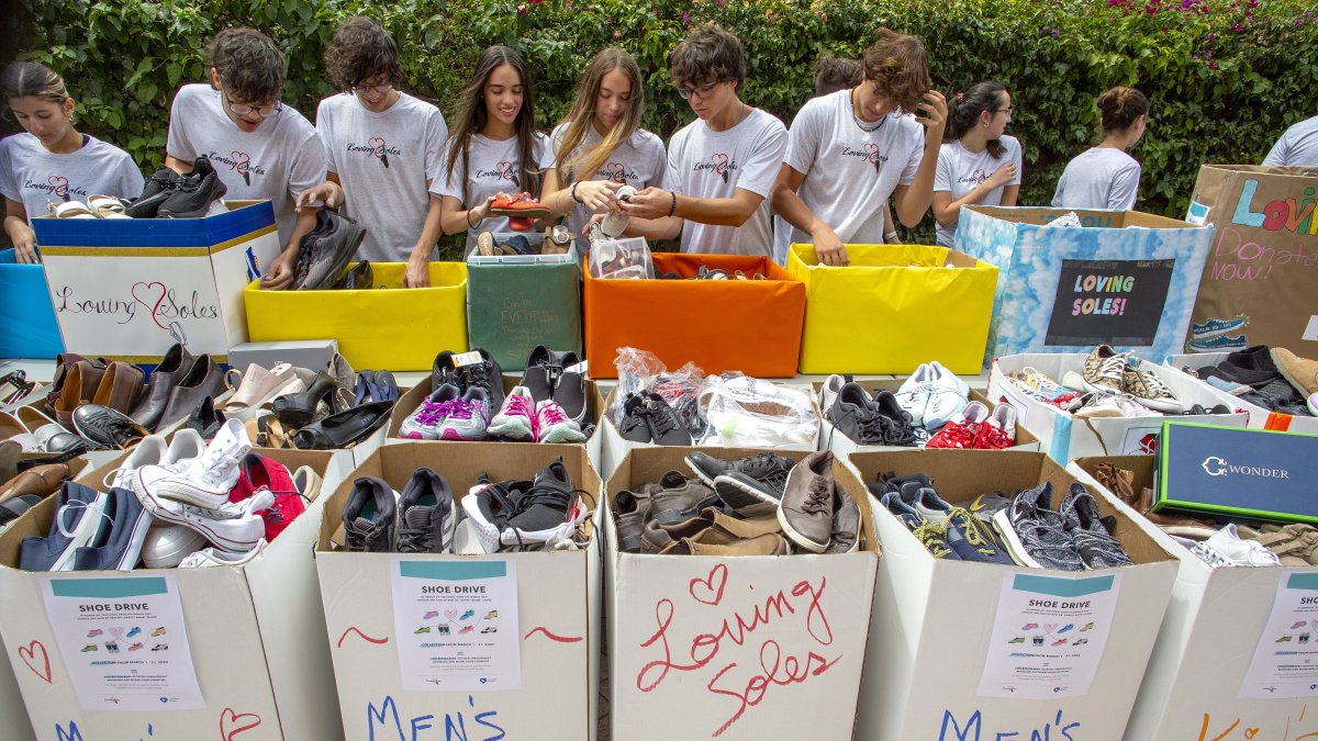 Miembros de 'Loving Soles', un proyecto de jóvenes que recolecta zapatos para compartir con personas necesitadas, fueron regitrados al clasificar las donaciones, en Miami Lakes (Florida, EE.UU.).