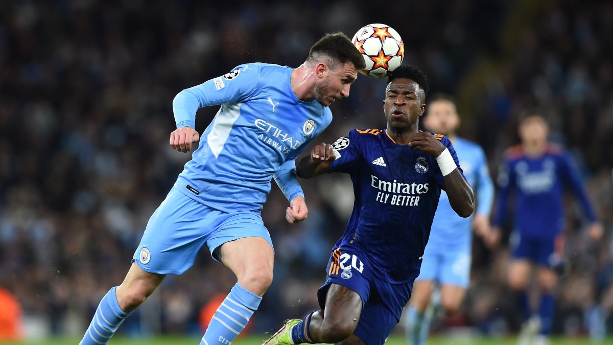 Aymeric Laporte, del City, disputa el balón con el madridista Vinicius Junior.