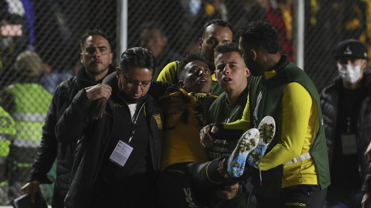 Jaime Arrascaita (c) de Strongest es llevado a una ambulancia en un partido de la Copa Libertadores entre The Strongest y Caracas FC en el estadio Hernando Siles en La Paz (Bolivia), este 27 de abril de 2022.